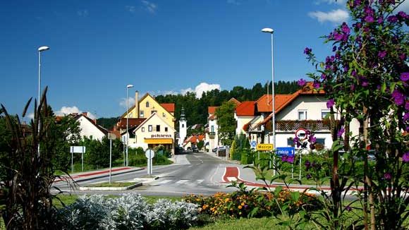 Krožišče in ulica v Mozirju s hišami in zelenjem