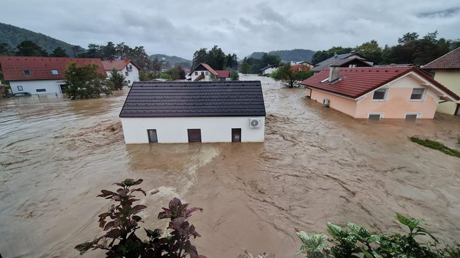 Poplavljene hiše in cesta v deroči vodi